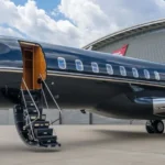 A sleek, modern private jet on a tarmac at sunset, with a couple in luxurious attire walking towards it, evoking a sense of exclusivity and freedom. The term "private jet charter" is subtly visible.
